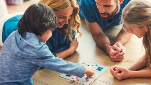 Family playing a board game together on the floor