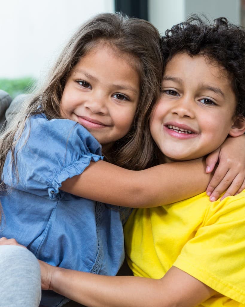 Two children smiling and hugging