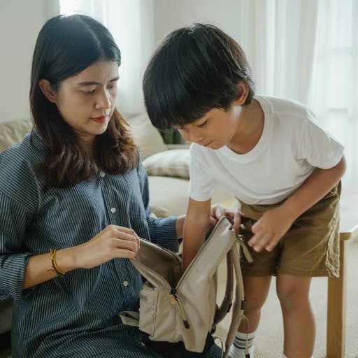 Parent and child packing a backpack together