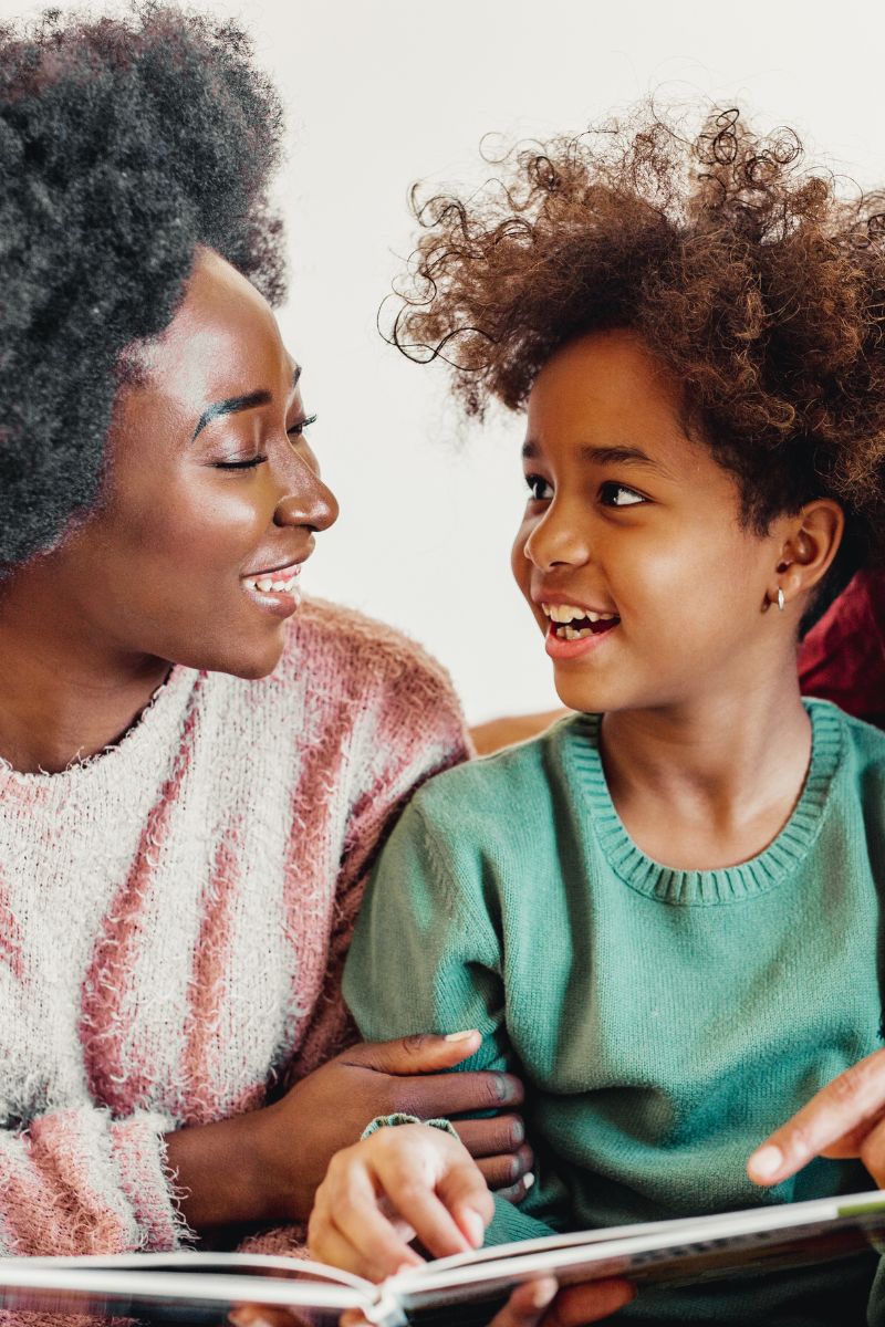 A parent and child hugging outdoors in warm golden light